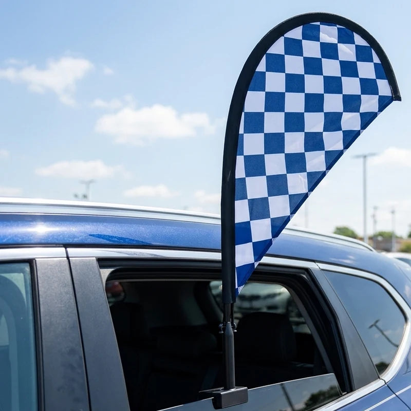 Blue and white checkered teardrop flag on a car window at a dealership lot